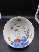 A JAPANESE IMARI BOWL PAINTED WITH BUTTERFLIES AND FLOWERS WITH WOODEN STAND. Dia.24.5cms.