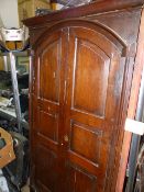 AN EARLY CARVED OAK RAISED PANEL DOOR OF ARCHED FORM.