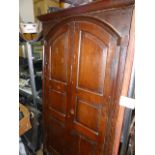 AN EARLY CARVED OAK RAISED PANEL DOOR OF ARCHED FORM.