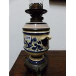 A VICTORIAN OIL LAMP WITH BLUE AND WHITE BODY AND RESERVOIR ON A BRONZE STAND CAST WITH SPREAD