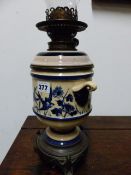 A VICTORIAN OIL LAMP WITH BLUE AND WHITE BODY AND RESERVOIR ON A BRONZE STAND CAST WITH SPREAD