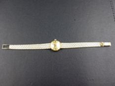 A LADIES GOLD OMEGA WRIST WATCH, STAMPED 585 AND TESTED AS 14ct. ON A BRICK STYLE BRACELET WITH A