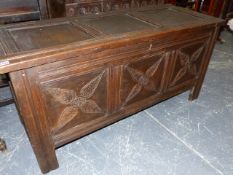 AN 18th.C.OAK COFFER WITH THREE PANEL TOP OVER CONFORMING CARVED PANEL FRONT AND STILE SUPPORTS. 132