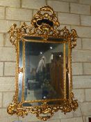 A LARGE CARVED GILTWOOD ITALIAN BAROQUE STYLE MARGINAL MIRROR. 184 x 124cms.