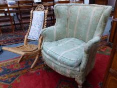 A CONTINENTAL WINGBACK ARMCHAIR WITH CARVED GILTWOOD LEGS TOGETHER WITH A VICTORIAN CARVED