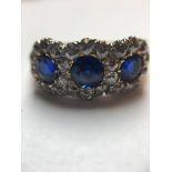 A SAPPHIRE AND DIAMOND RING SET IN PRECIOUS YELLOW AND WHITE METAL (TESTS AS GOLD). THREE BLUE