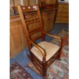 A LATE VICTORIAN ROCKING CHAIR WITH LADDER BACK AND RUSH SEAT.