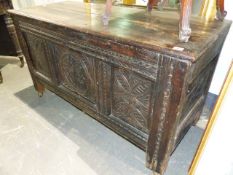 AN 18th.C.OAK COFFER WITH PLANK TOP AND CARVED, THREE PANEL FRONT, LONG STILE FEET AND LATER