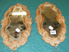 A PAIR OF 19th.C.CONTINENTAL CARVED ROCOCO STYLE SMALL MIRRORS OF SHAPED FORM. H.37cms.