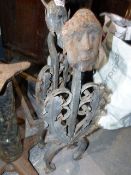 A PAIR OF VINTAGE WROUGHT IRON FIGURAL FORM ANDIRONS WITH MASK FINIALS AND SCROLLWORK DECORATED