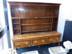 AN INLAID GEORGIAN COUNTRY OAK THREE DRAWER DRESSER WITH ASSOCIATED PLATE RACK AND PIERCED GEOMETRIC