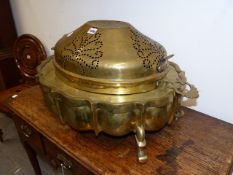 A LARGE BRASS SHAPED OVAL FORM PERSIAN BRAZIER WITH PIERCED COVER AND SCROLL FORM LEGS. W.75cms.