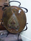 AN ARTS AND CRAFTS COPPER AND WROUGHT IRON OVAL FIRESCREEN DECORATED WITH STYLISED TENDRILS AND