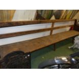 AN ANTIQUE RUSTIC PINE BENCH, REPUTEDLY FROM THE QUAKER MEETING HOUSE AT SHIPSTON ON STOUR.