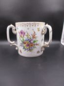 A DRESDEN PORCELAIN THREE HANDLED TYG PAINTED WITH BUNCHES OF FLOWERS BELOW A GILT SCROLL AND