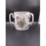 A DRESDEN PORCELAIN THREE HANDLED TYG PAINTED WITH BUNCHES OF FLOWERS BELOW A GILT SCROLL AND