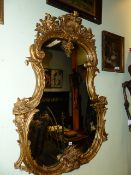 AN ANTIQUE FRENCH ROCOCO STYLE CARTOUCHE FORM PIER MIRROR. W.100 x H.138cms.