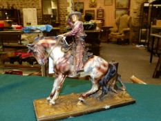 A 1920'S COLD PAINTED SPELTER RODEO RIDER TABLE LIGHTER, THE COWBOY ON A SKEWBALD ABOUT TO THROW HIS