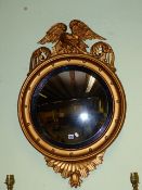 A 19th.C.CARVED GILTWOOD CONVEX MIRROR WITH EAGLE CREST. H.98cms.