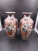 A PAIR OF JAPANESE IMARI VASES EACH PAINTED WITH TWO RESERVES OF A MOTHER AND CHILD IN A FLOWER