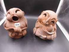 A PAIR OF HUMOROUS TERRACOTTA FIGURES, ONE SEATED IN SONG AND THE OTHER WITH POUTING LIPS. H.