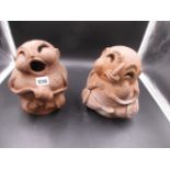 A PAIR OF HUMOROUS TERRACOTTA FIGURES, ONE SEATED IN SONG AND THE OTHER WITH POUTING LIPS. H.