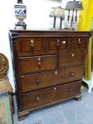 A GEORGIAN OAK CHEST OF FIVE SHORT AND TWO LONG DRAWERS WITH PANELLED SIDES STANDING ON OGEE BRACKET