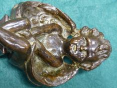 A SMALL ANTIQUE BRONZE FIGURE OF A SEATED WINGED CHERUB, UNSIGNED BUT ATTRIBUTED BY REPUTE TO