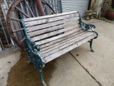 A VICTORIAN AND LATER PAINTED GREEN CAST IRON GARDEN BENCH.