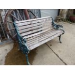 A VICTORIAN AND LATER PAINTED GREEN CAST IRON GARDEN BENCH.