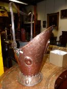 AN ARTS AND CRAFTS WROUGHT IRON MOUNTED COPPER HELMET FORM COAL SCUTTLE WITH RAISED OVAL BOSSES