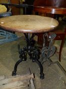 AN ANTIQUE CAST IRON BASE CIRCULAR TABLE, CIRCULAR OAK TOP ABOVE GOTHIC REVIVAL STYLE TRIFID BASE.