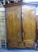 A LARGE FRENCH PROVINCIAL TWO DOOR ARMOIRE WITH BRASS LOCK PLATES AND HINGES OVER THREE DRAWERS