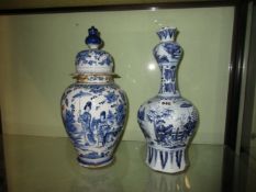 A DELFT POTTERY VASE WITH ELONGATED NECK DEPICTING AN ORIENTAL PAINTED SCENE. H.38cms AND A DELFT