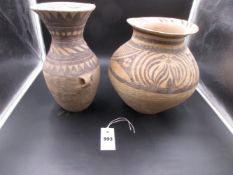 TWO TERRACOTTA VASES GEOMETRICALLY PAINTED IN DARK BROWN AND RED, THE BALUSTER SHAPE WITH LUG