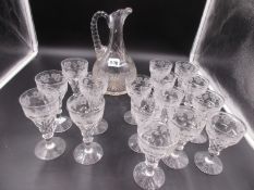 A GLASS CLARET CARAFE, ELEVEN SMALLER GLASSES, H.10.5cms AND FIVE TALLER ENGRAVED WITH GRAPE VINES