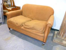 AN EDWARDIAN COUNTRY HOUSE SMALL SETTEE ON SQUARE TAPERED LEGS AND HARROD'S BRASS CASTORS. W.