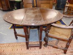 AN 18th.C.AND LATER OAK COTTAGE GATELEG TABLE, THE TOP WITH BORDER CARVED DECORATION OVER GUN BARREL