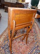 AN EARLY 20th.C.OAK CAMPAIGN TYPE FOLDING WRITING TABLE ON X FRAME SUPPORTS.