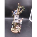 A MEISSEN GROUP OF CHILDREN HARVESTING A PEAR TREE. H.26.5cms.