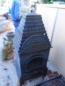 A CAST IRON ARCHITECTURAL OUTDOOR FIRE ENCLOSURE WITH STEPPED COVER. OVERALL H.125cms.