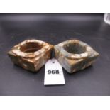 TWO SIMILAR MOTTLED BROWN AND GREY HARDSTONE CONGS VARIOUSLY CALCINED, THE CYLINDRICAL HOLES