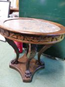 AN ITALIANATE CARVED OAK MARBLE TOP CIRCULAR CENTRE TABLE WITH SCROLL SUPPORTS, PAW FEET AND