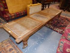 A VICTORIAN CAMPAIGN TYPE FOLDING DAY BED WITH CANE PANELS STANDING ON TURNED LEGS WITH BRASS