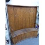 AN ANTIQUE COUNTRY MADE PINE HIGHBACK SETTEE OF CURVED FORM. W.190 x H.171cms.