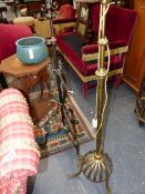 A VICTORIAN WROUGHT IRON OIL STANDARD LAMP ADAPTED FOR ELECTRICITY AND A SIMILAR BRASS EXAMPLE.