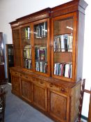 A VICTORIAN MAHOGANY BREAK FRONT BOOKCASE, WITH FOUR GLAZED DOORS OVER FOUR DRAWERS AND ENCLOSED CAB
