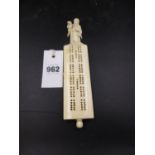 A CHINESE IVORY CRIBBAGE BOARD WITH CARVED FIGURAL HANDLE AND PEG HOLDER IN BASE.