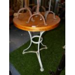 A PAIR OF ANTIQUE FRENCH IRON CAFE TABLES WITH LATER OAK TOPS. Dia.56 x H.74cms. (2)`