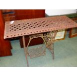 A VINTAGE CAST IRON GARDEN TABLE FORMED FROM A SINGER SEWING MACHINE BASE WITH A VICTORIAN PIERCED